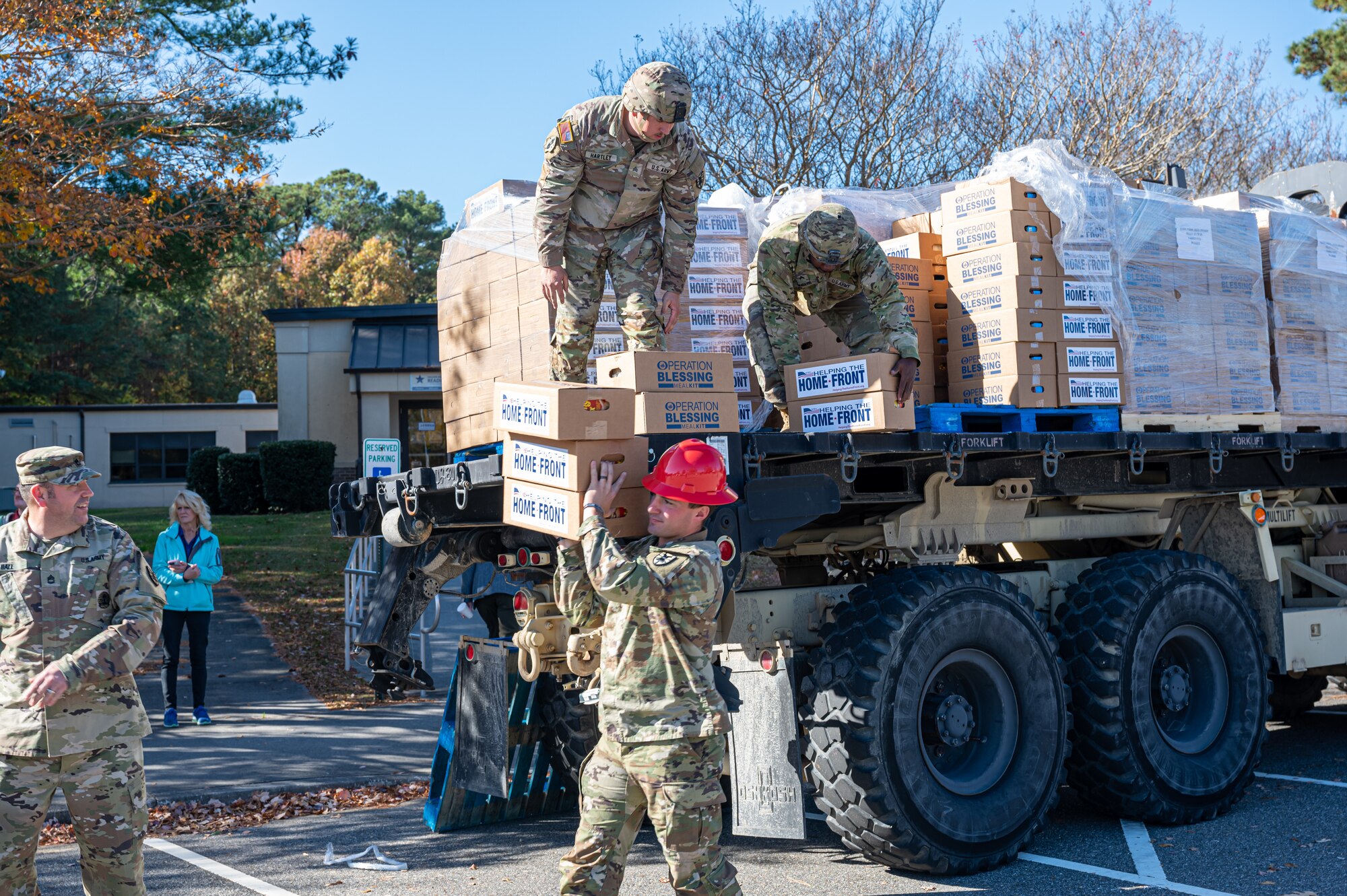 Soldiers remove food from a pallet truck