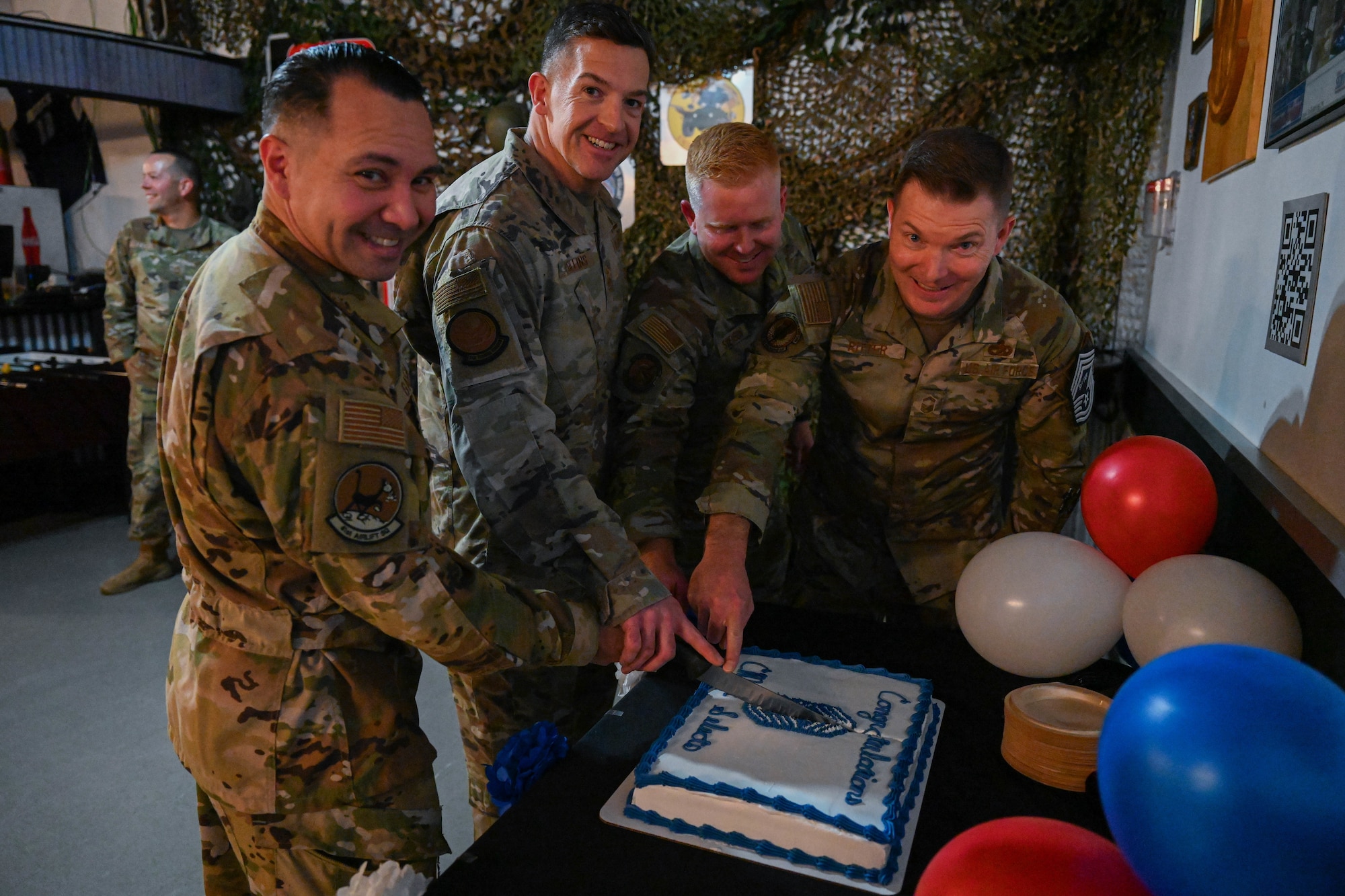 A group of people cut a cake.