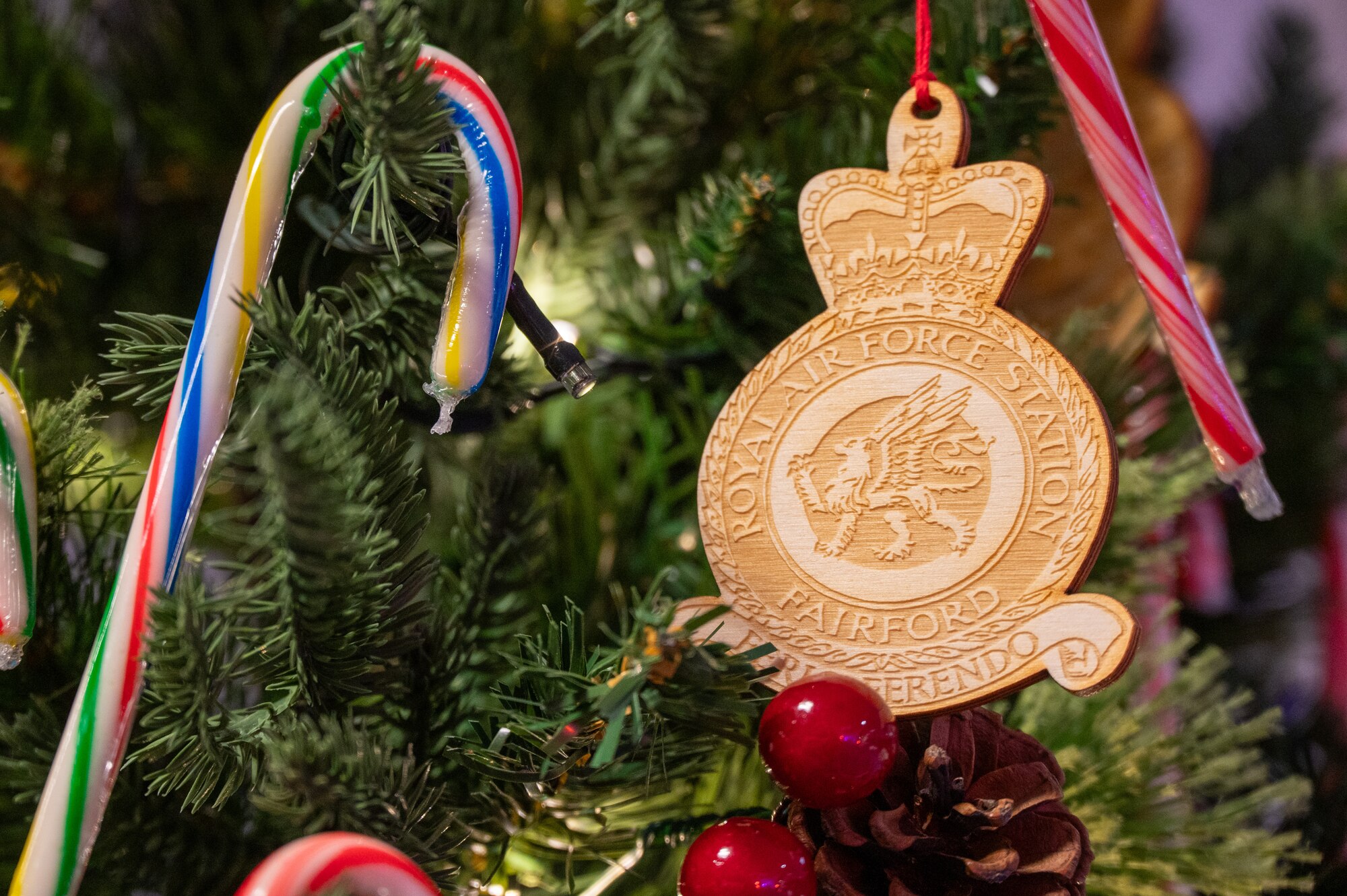 A custom holiday ornament hangs on a Christmas tree.