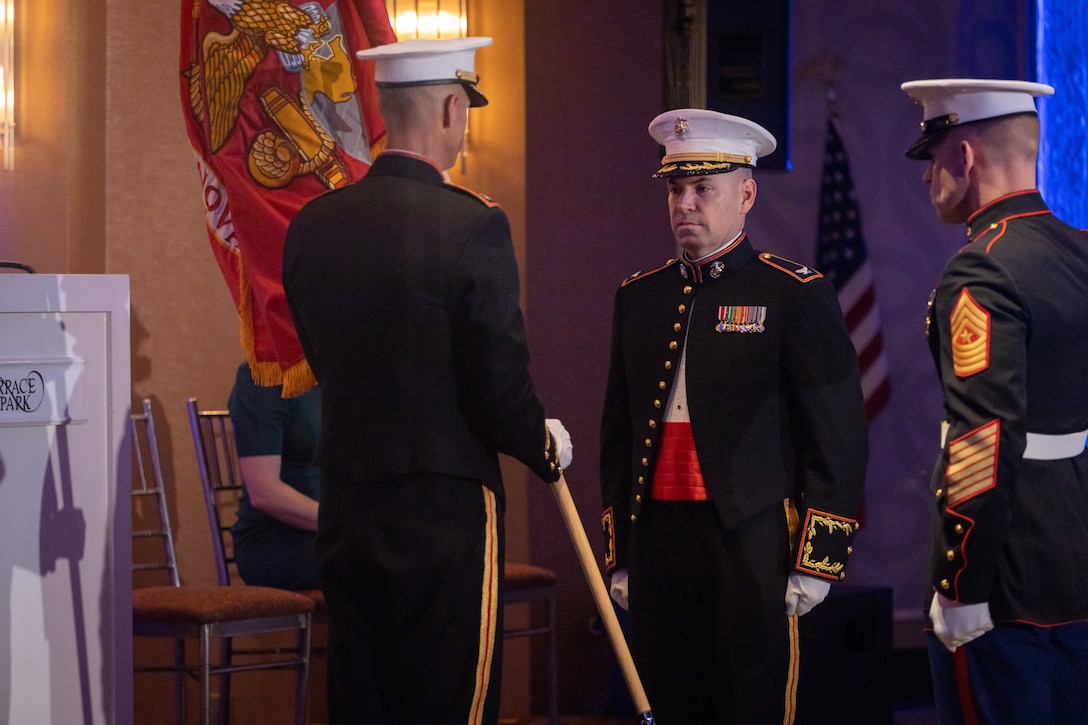 U.S. Marine Corps Col. Matthew Swindle, left, outgoing commanding officer of the Marine Innovation Unit, holds the colors during a change of command ceremony, Queens, New York, Nov. 5, 2023. The ceremony occurred at a ball hosted by MIU, celebrating the Marine Corps' 248th annual birthday. Col. Brooks Braden, right, assumed command of MIU. Stood up in March 2022, the unit leverages existing Marine talent in order to: accelerate the adoption of advanced capabilities; transform Naval Service capacity for technology employment; and retain and invest in Total Force human capital. (U.S. Marine Corps photo by Lance Cpl. David Intriago)