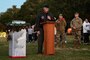 Col. Michael Maginness speaks outside at a podium