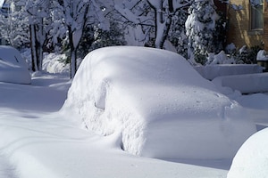 Car on city street after large snowfall.