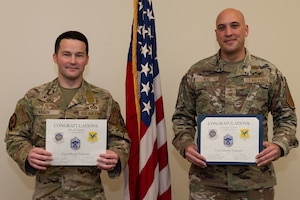 U.S. Air Force Senior Master Sgts. Kyle Nason, left, 436th Civil Engineer Squadron Explosive Ordnance Disposal flight superintendent, and Christian Ruiz, right, 436th Aerial Port Squadron air freight superintendent, hold their certificate announcing their promotion to chief master sergeant at Dover Air Force Base, Delaware, Nov. 29, 2023. Nason and Ruiz were two of 506 Airmen selected for promotion to the top enlisted rank of chief for the 23E9 promotion cycle. (U.S. Air Force photo by Roland Balik)