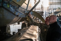 Rear Adm. Robert Wirth, J5N, U.S. Strategic Command deputy director, strategic targeting and nuclear mission planning, is briefed by Tech Sgt. Bryce Gex, 5th Maintenance Group weapons load crew standardization member, on the capabilities of the air-launched cruise missile (ALCM) at Minot Air Force Base, North Dakota, Nov. 29, 2023. During his visit to Minot, Wirth toured a B-52H Stratofortress static display and a weapons loader trainer. (U.S. Air Force photo by Airman 1st Class Alexander Nottingham)