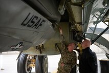 Rear Adm. Robert Wirth, J5N, U.S. Strategic Command deputy director, strategic targeting and nuclear mission planning, is briefed by Tech Sgt. Bryce Gex, 5th Maintenance Group weapons load crew standardization member, on the capabilities of the air-launched cruise missile (ALCM) at Minot Air Force Base, North Dakota, Nov. 29, 2023. The B-52H can carry approximately 70,000 pounds of mixed ordnance—bombs, mines and missiles. (U.S. Air Force photo by Airman 1st Class Alexander Nottingham)