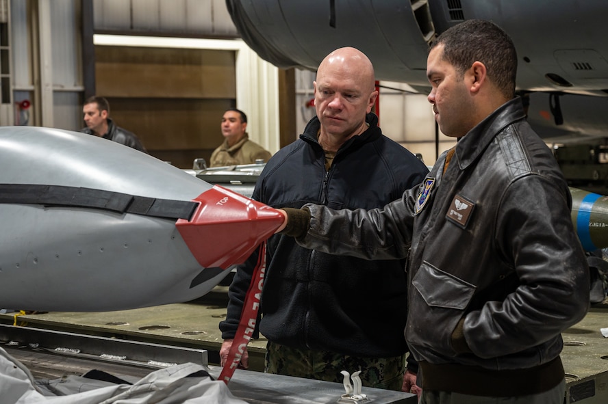Rear Adm. Robert Wirth, J5N, U.S. Strategic Command deputy director, strategic targeting and nuclear mission planning, is briefed by U.S. Air Force Capt. Nathan Fisher, 23rd Bomb Squadron instructor and radar navigator, on the different munitions carried by the B-52H Stratofortress at Minot Air Force Base, North Dakota, Nov. 29, 2023. The B-52H can carry approximately 70,000 pounds of mixed ordnance—bombs, mines and missiles. (U.S. Air Force photo by Airman 1st Class Alexander Nottingham)