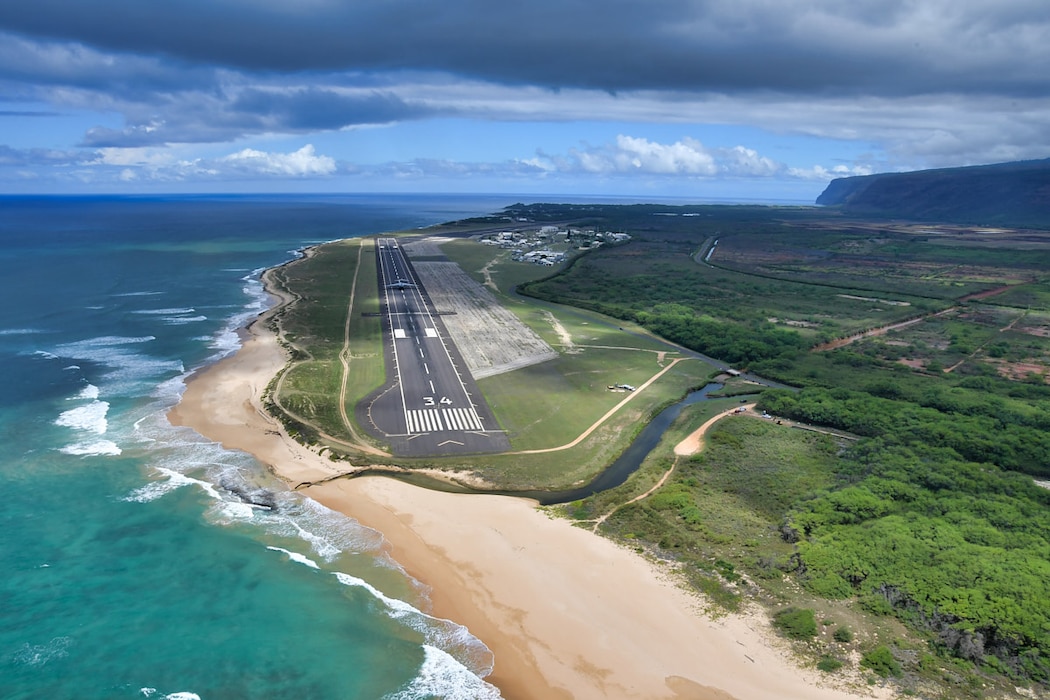 runway, blue ocean, and green fields are seen in aerial view of Pacific Missile Range Facility