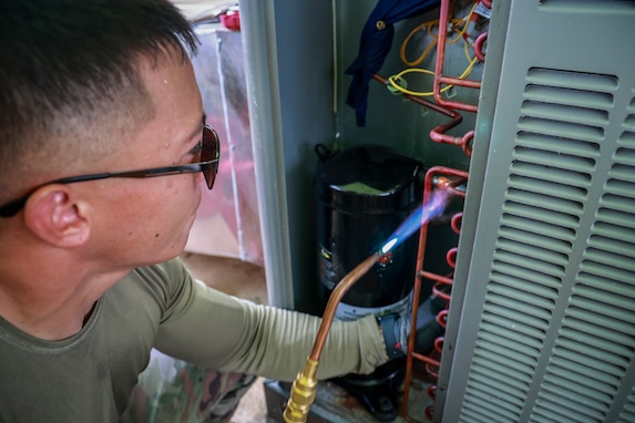 Staff Sgt. Bryant Contreras of the 254th Red Horse Squadron, Guam Air National Guard, “sweats” an HVAC copper pipe on Andersen Air Force Base, Guam, Nov. 27, 2023. Contreras is activated with a group of 30 Guam Guardsmen tasked to restore 50 homes for rotational forces in Guam. (U.S. National Guard photo by Mark Scott)