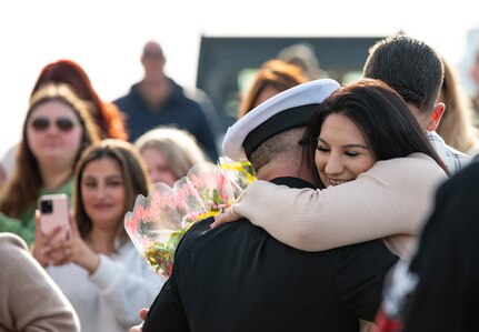 A Sailor assigned to the Arleigh Burke-class guided-missile destroyer USS Paul Ignatius (DDG 117) greets his family on the pier at Naval Station (NAVSTA) Rota as the ship returns from deployment, Nov. 28, 2023. As the "Gateway to the Mediterranean,” NAVSTA Rota provides U.S, NATO and allied forces a strategic hub for operations in Europe, Africa and the Middle East. NAVSTA Rota is a force multiplier, capable of promptly deploying and supporting combat-ready forces through land, air and sea, enabling warfighters and their families, sustaining the fleet and fostering the U.S. and Spanish partnership. (U.S. Navy photo by Mass Communication Specialist 2nd Class Drace Wilson)