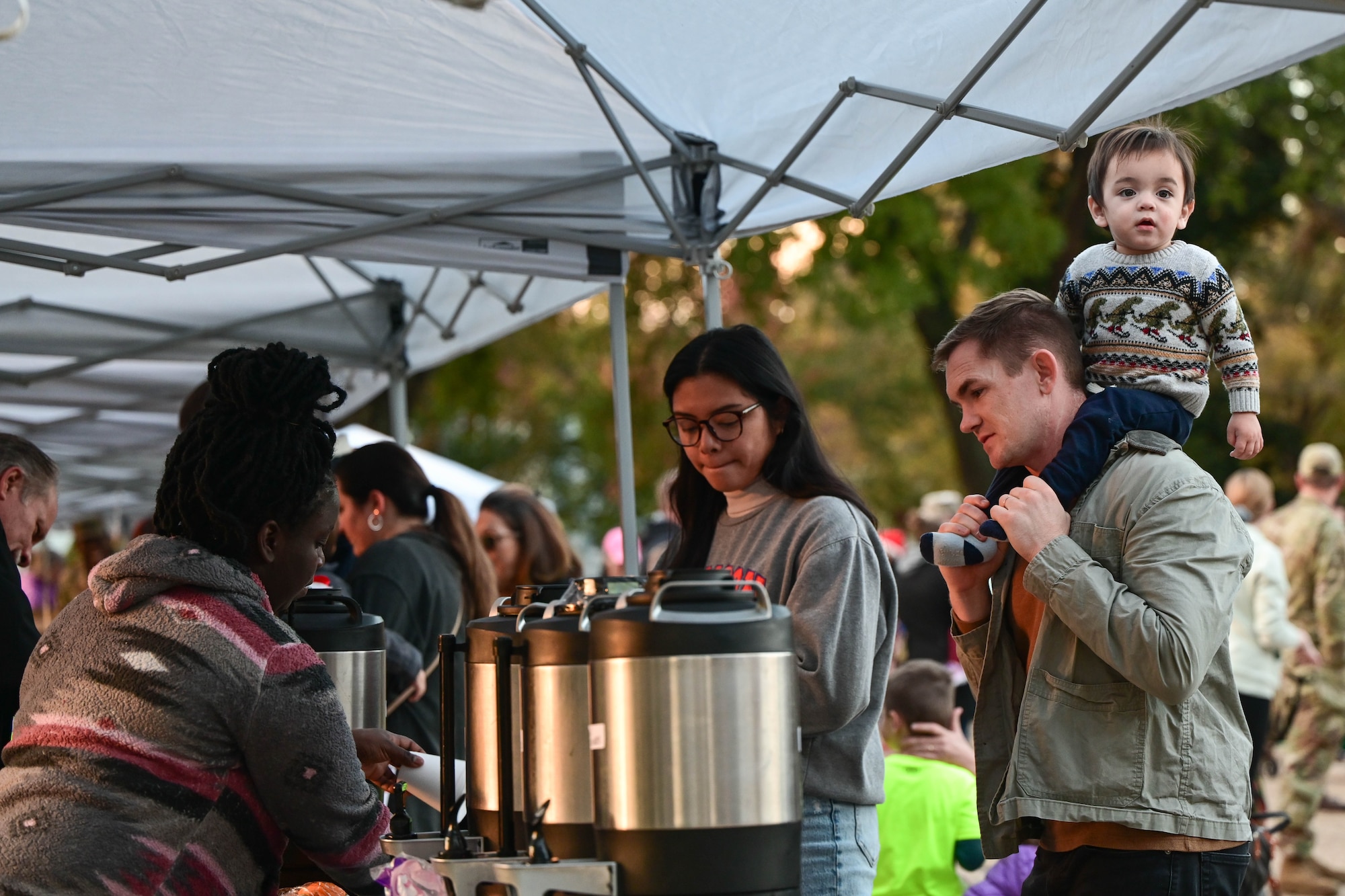 A woman prepares a hot chocolate for a family who is at her booth