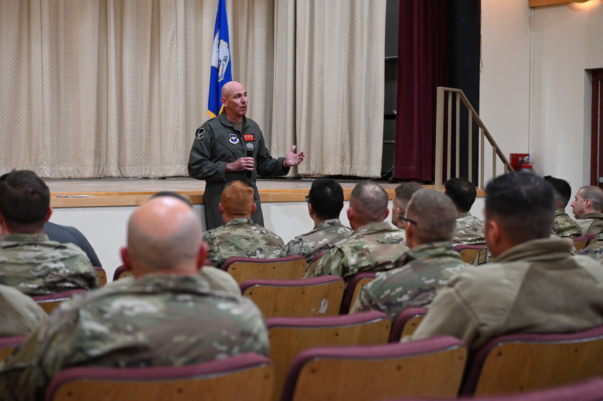 General talking and gesturing to crowd of Airmen seated