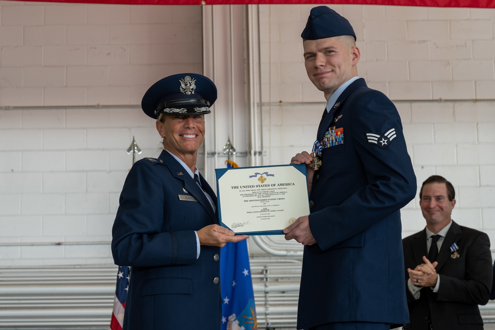 Two individuals hold a certificate.