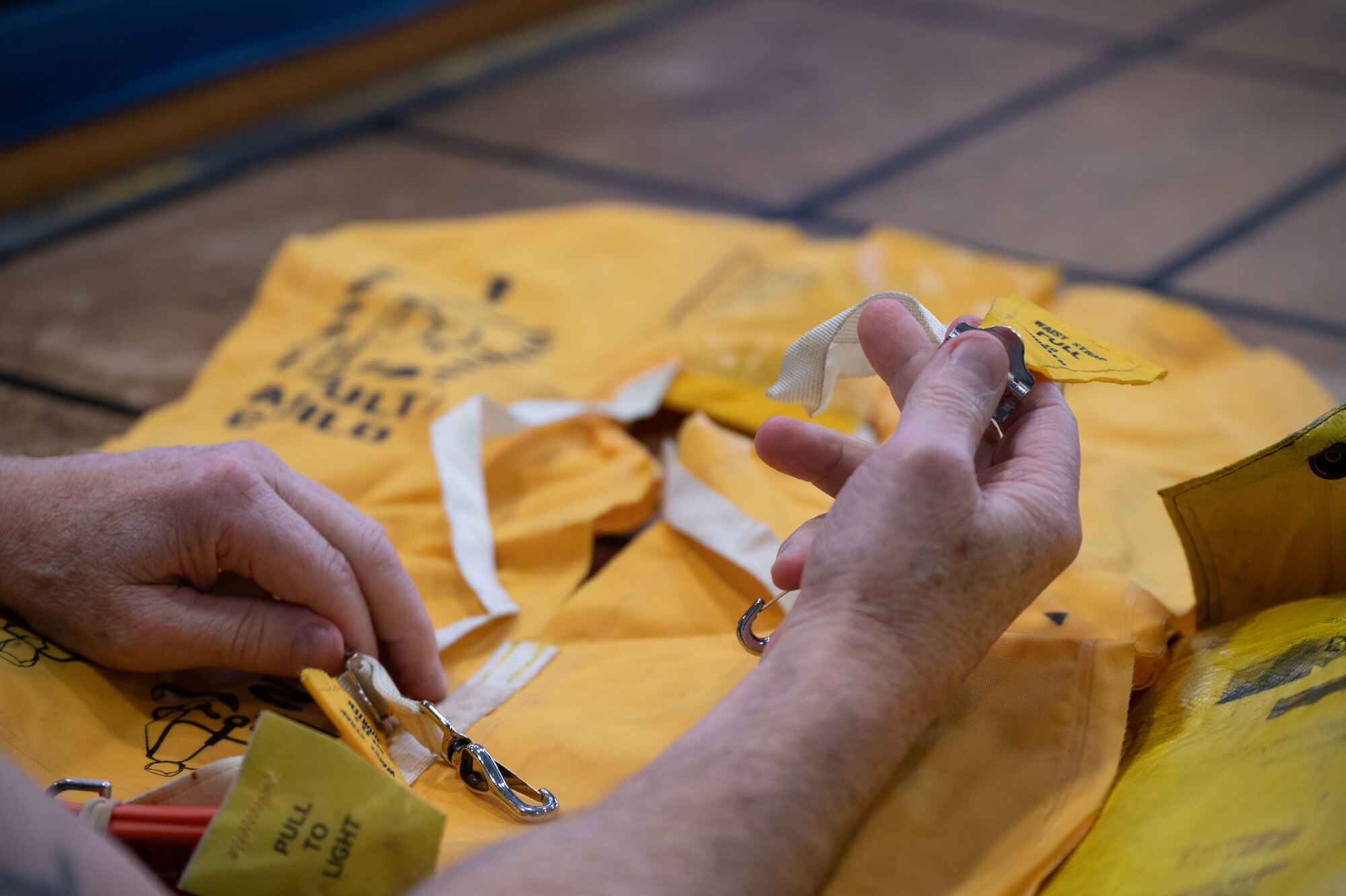 David Compton, 436th Operations Squadron aircrew flight equipment craftsman, inspects a life preserver at Dover Air Force Base, Delaware, Nov. 27, 2023. The 436th OSS provides air traffic control, weather, intelligence, mission planning and more to ensure that Team Dover is always prepared to provide rapid global transportation. (U.S. Air Force photo by Airman 1st Class Dieondiere Jefferies)