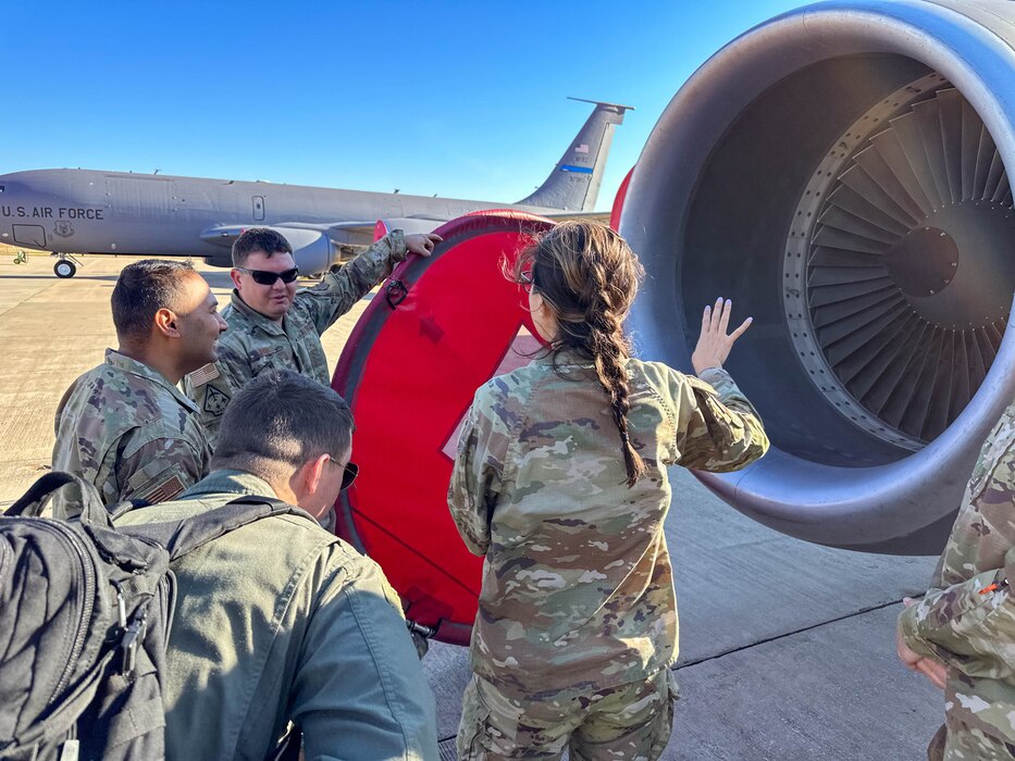 people standing around a jet engine