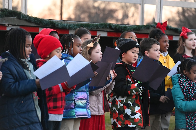 Children sing using sheet music during the annual Christmas Tree and Menorah Lighting ceremony