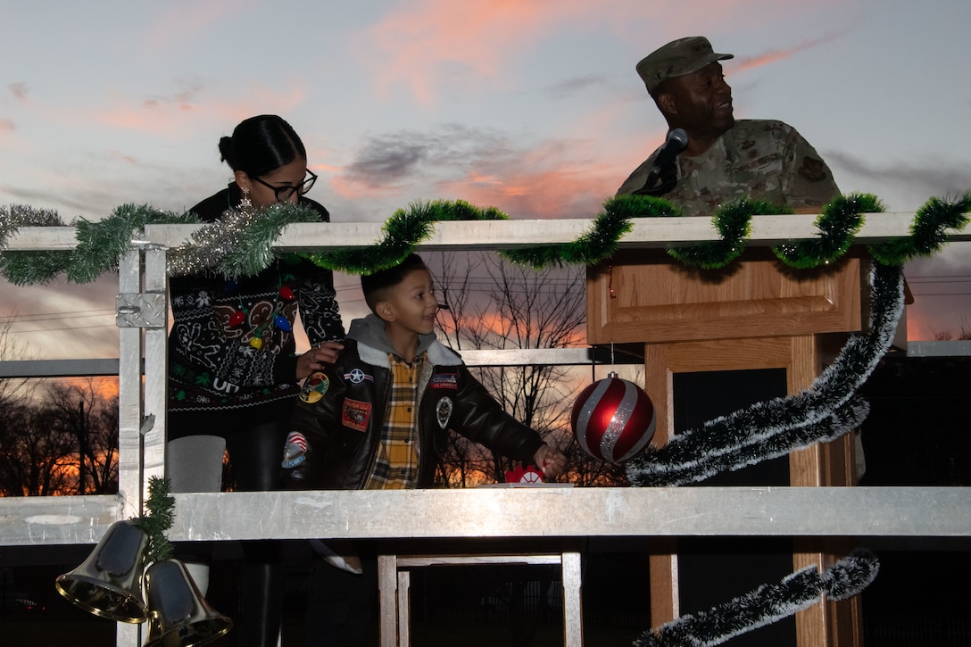 From left, Samantha Magallon Ochoa, Camden Magallon Ochoa and Col. Todd E. Randolph, 316th Wing and installation commander, flip the power switch during the annual Christmas Tree and Menorah Lighting