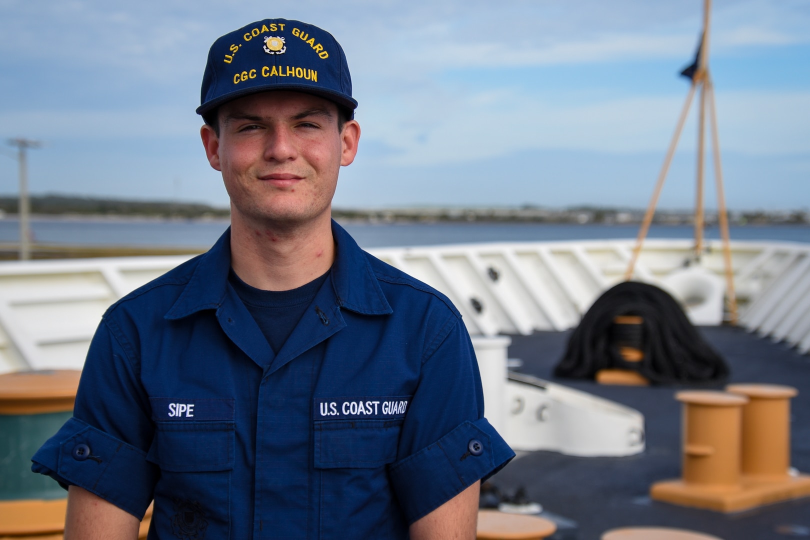 U.S. Coast Guard Seaman Alec Sipe, a crewmember assigned to the Coast Guard Cutter Calhoun (WMSL 759),  poses for a portrait on the focsle of the Calhoun at Naval Station Mayport, Florida, Dec. 1, 2023. Sipe works in the deck department and intends to pursue the machinery technician rating following his tour aboard the Calhoun.