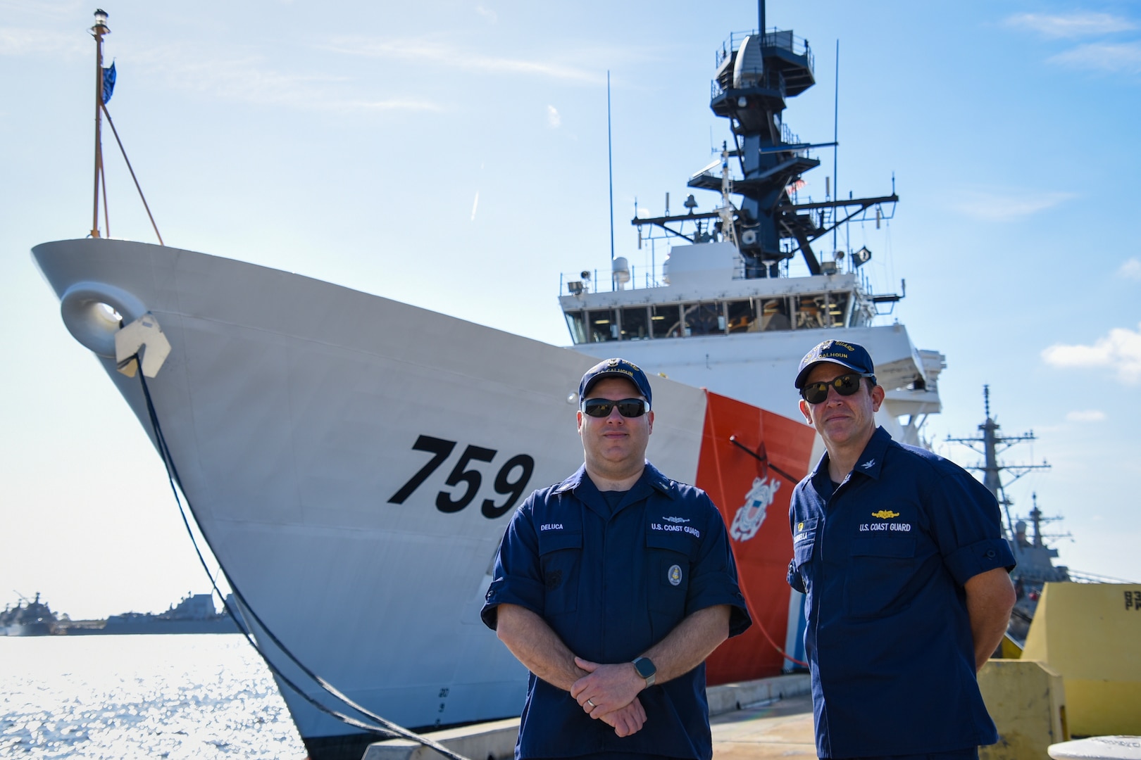 U.S. Coast Guard Capt. Timothy Sommella, commanding officer of the Coast Guard Cutter Calhoun, and Senior Chief Petty Officer Aaron Deluca, command senior enlisted leader, pose for a portrait in front of the Coast Guard Cutter Calhoun (WMSL 759) at Naval Station Mayport, Florida, Dec. 1, 2023. The cutter’s namesake, Master Chief Petty Officer Charles Calhoun, served as the Coast Guard’s first master chief petty officer from August 1969 to August 1973.