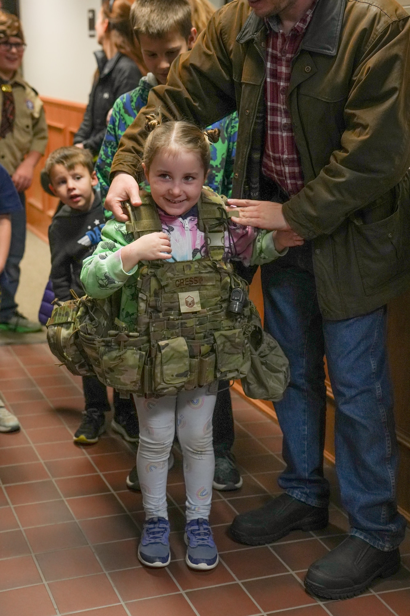 Evie Curnaw, a member of Boy Scouts of America Sioux Council Pack 208, tries on the gear of a Security Forces member during a trip to the South Dakota Air National Guard during December's unit training assembly at Joe Foss Field, December 2, 2023.