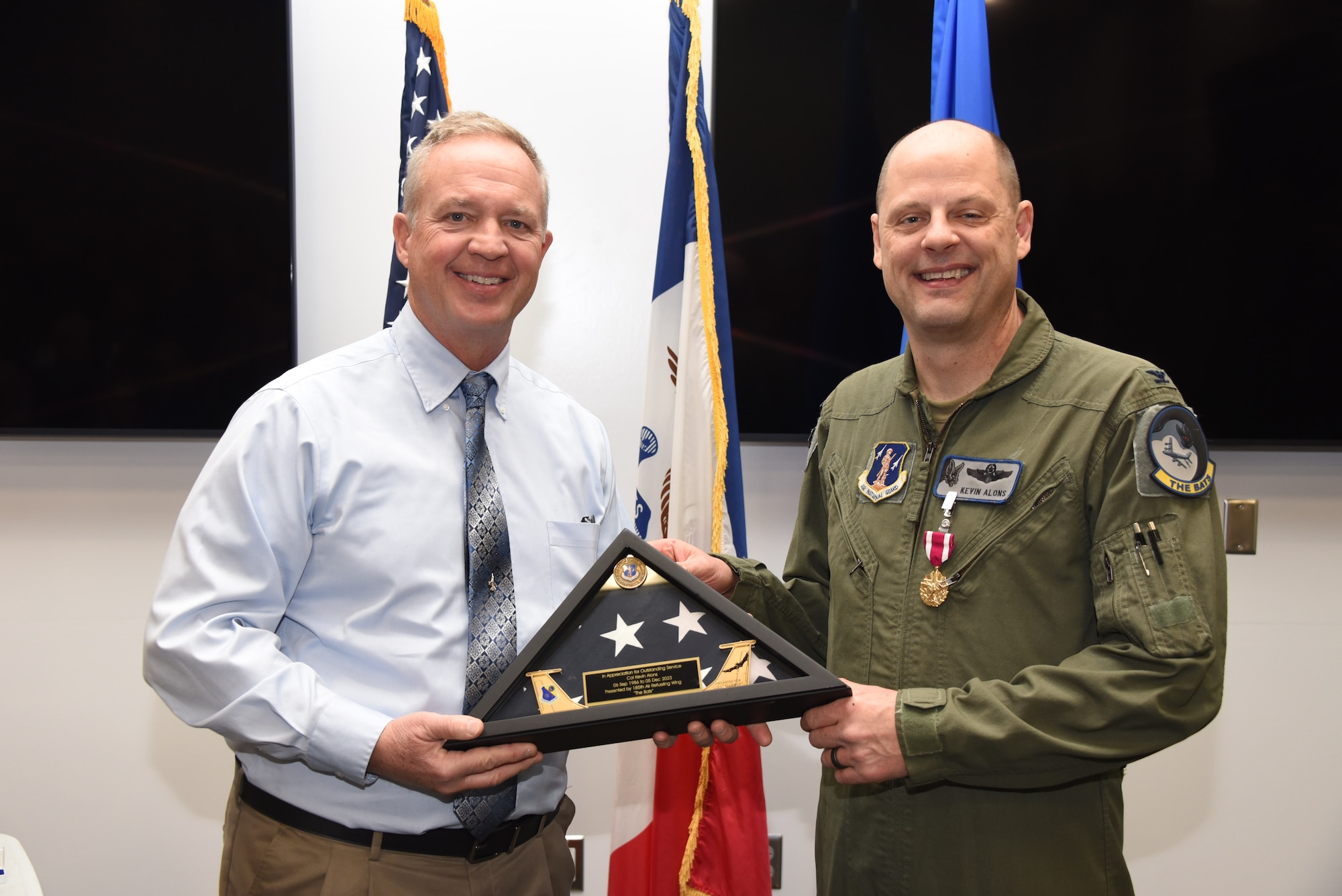U.S. Air National Guard Col. Kevin Alons, Director of Operations for Air for the Iowa Air National Guard, right, accepts a retirement flag from retired Brig. Gen. Lawrence Christensen, former Chief of Staff of the Iowa Air National Guard, left