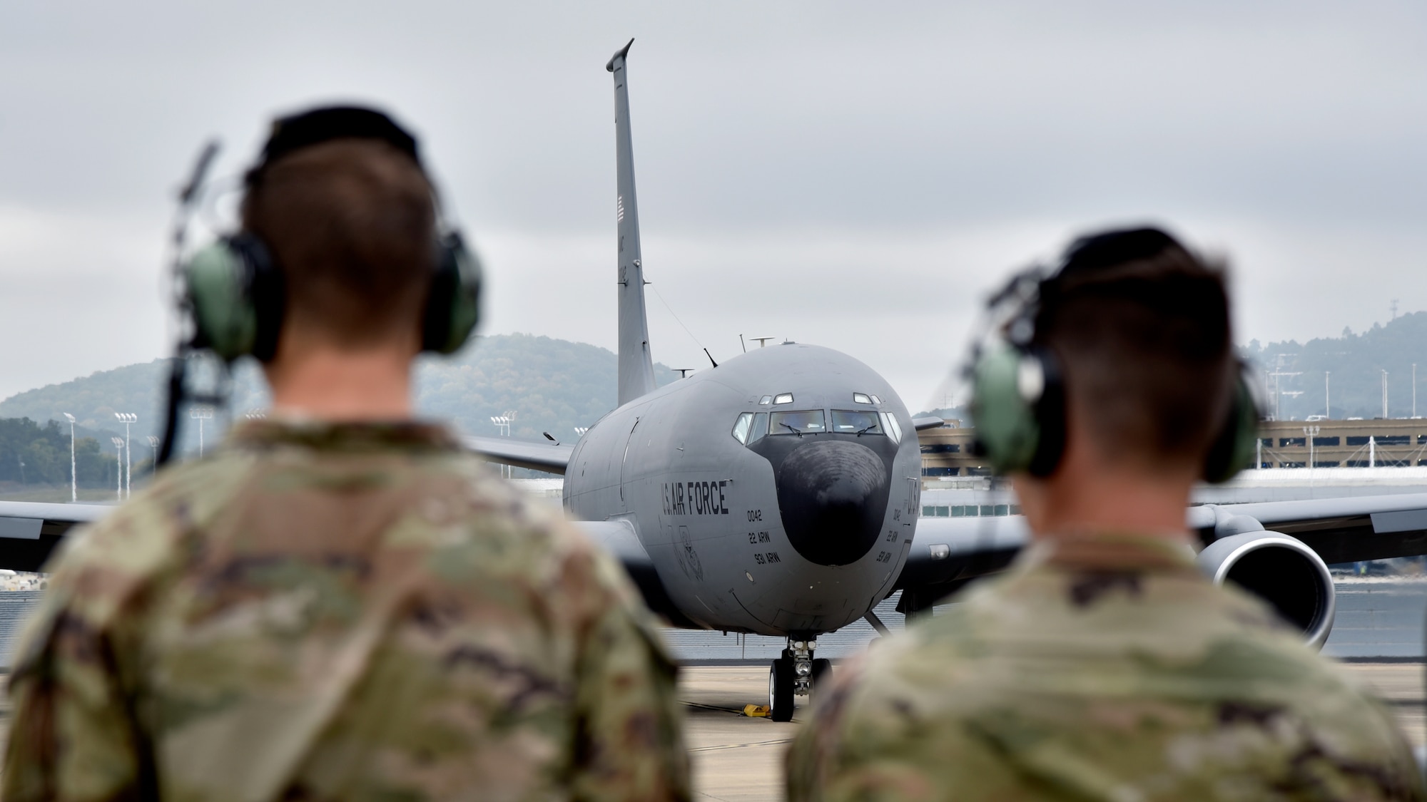 From left, U.S. Air Force Airman 1st Class Colin Sloane and Senior Airman Heath Isom, both 117th Aircraft Maintenance Squadron crew chiefs, look at a 117th Air Refueling Wing KC-135 Stratotanker on Oct. 14, 2023, at Sumpter Smith Joint National Guard Base, Alabama. The crew chiefs were standing at the ready for if they had to marshall taxing aircraft. (U.S. Air National Guard photo by Staff Sgt. Shelby Thurman)