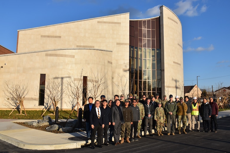 A group of US and ROK servicemembers and civilians stand outside the chapel at Osan Air Base.