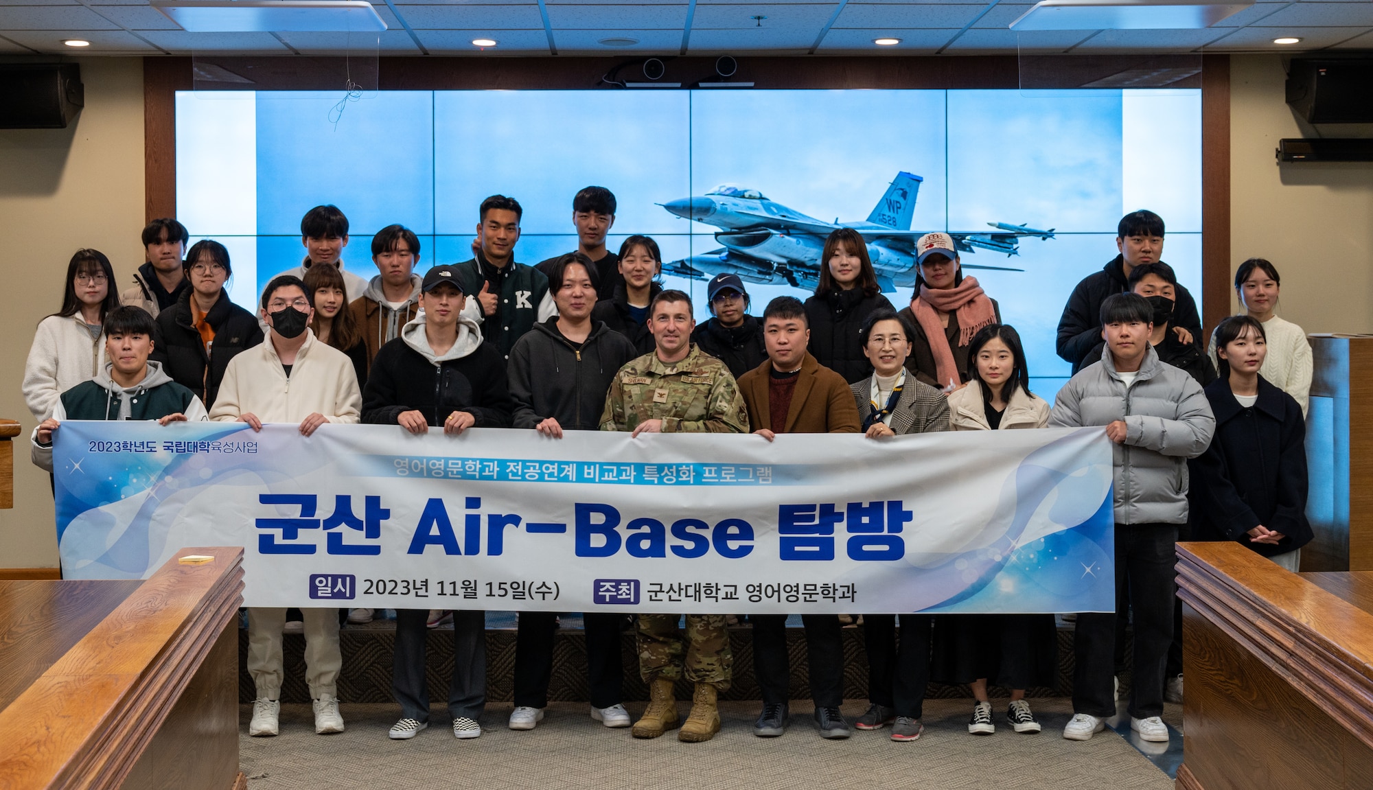 Col. Jeffrey D. Shulman stands for a photo with students from Kunsan National University during a base tour at Kunsan Air Base.
