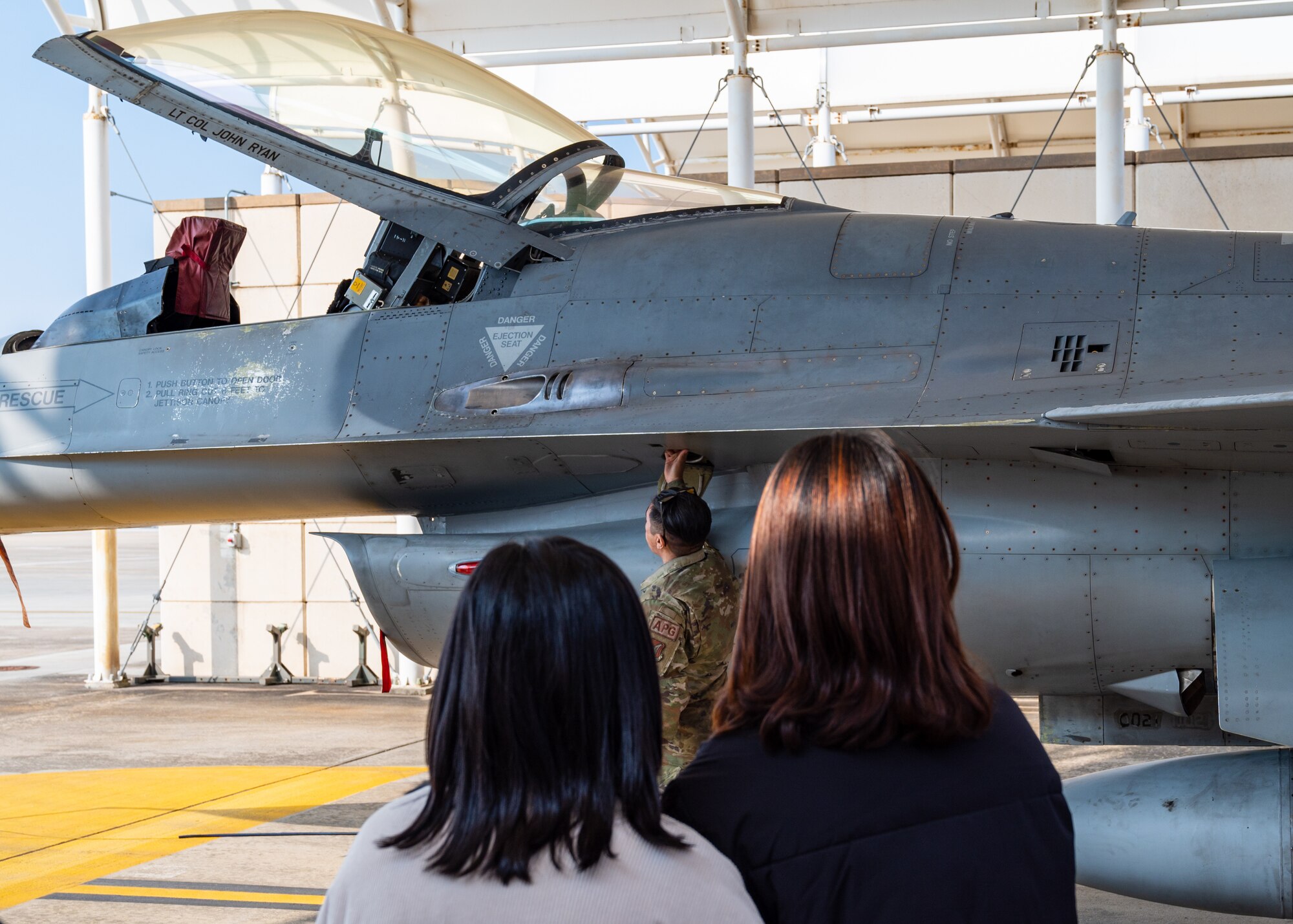 Senior Airman Bobby Spicer opens the canopy of an F-16 Fighting Falcon during a base tour at Kunsan Air Base.