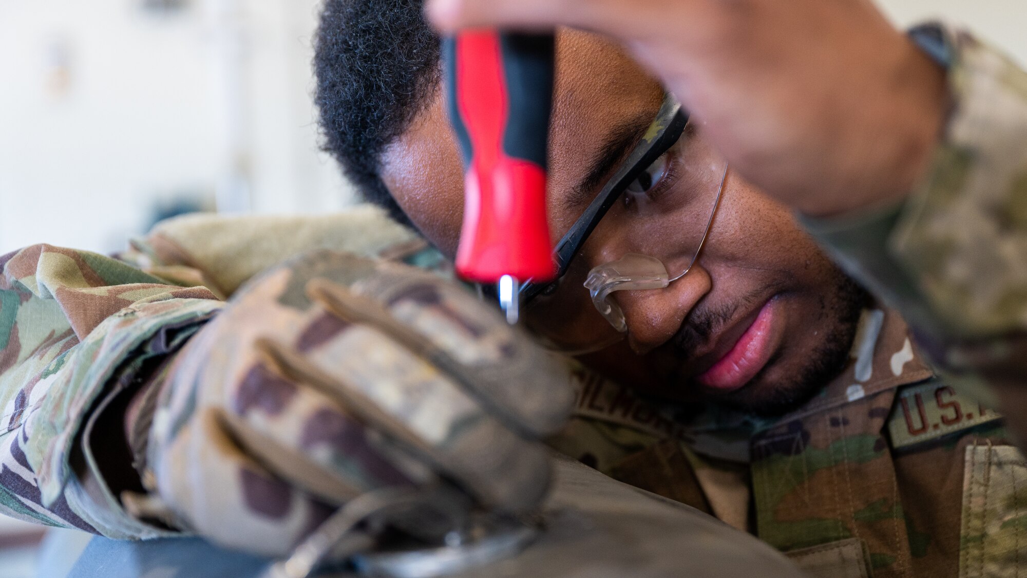 Airman 1st Class Khaliq Gilmore, 8th Maintenance Squadron conventional maintenance crew technician, unscrews a casing during the deconstruction of a guided bomb unit-31 version 3