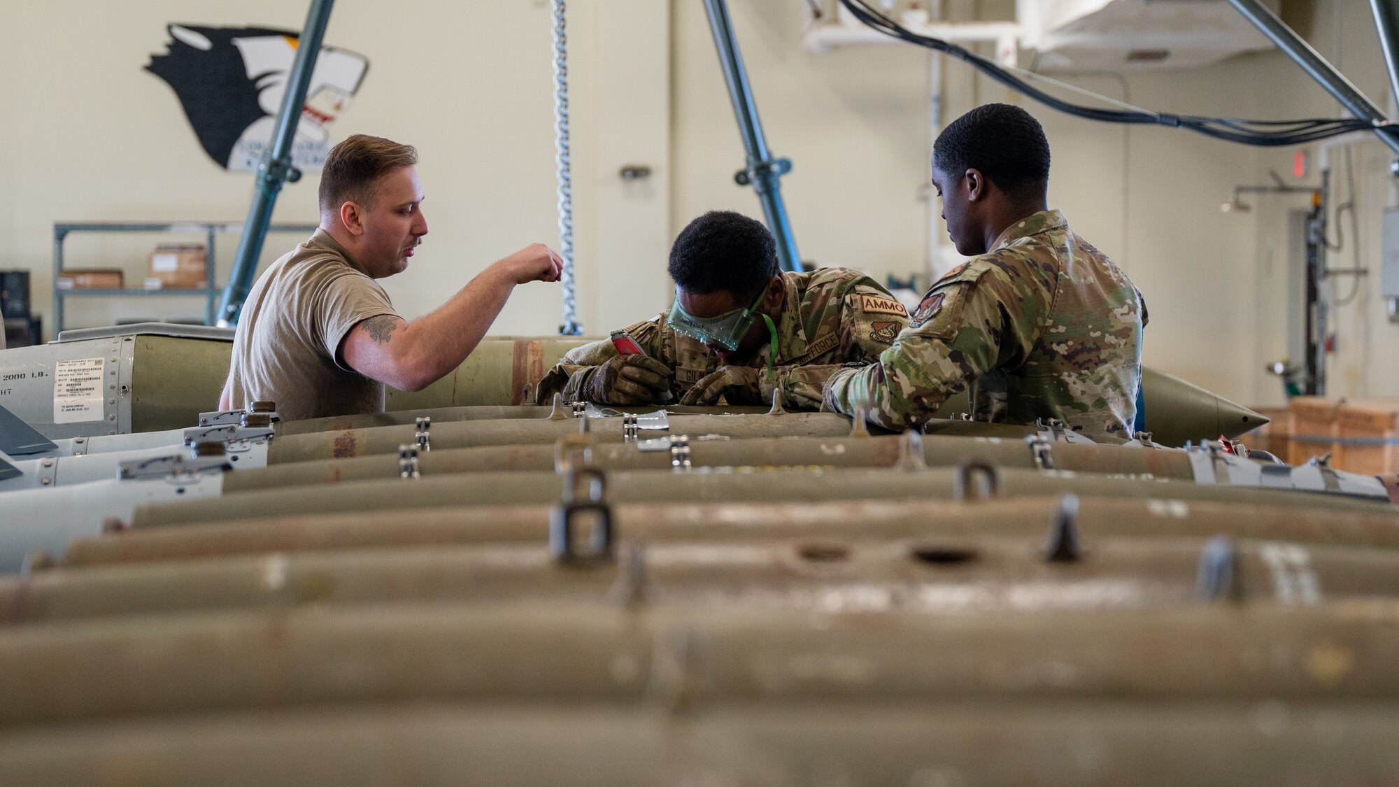 From left, Senior Airman Myles Friederich, 8th Maintenance Squadron conventional maintenance crew chief, with Airman 1st Class Khaliq Gilmore and Airman 1st Class Daven Woulard, 8th MXS conventional maintenance technicians, deconstruct a guided bomb unit-54 version 3