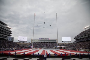 Soldiers assigned to the 1st Infantry Division perform a flyover during halftime at a Veterans Day game at the Bill Snyder Family Stadium, Nov. 11, 2023. The Fort Riley Day game is an annual tradition between Kansas State University and Fort Riley symbolizing their ongoing connection. (U.S. Army photo by Pfc. Koltyn O’Marah)