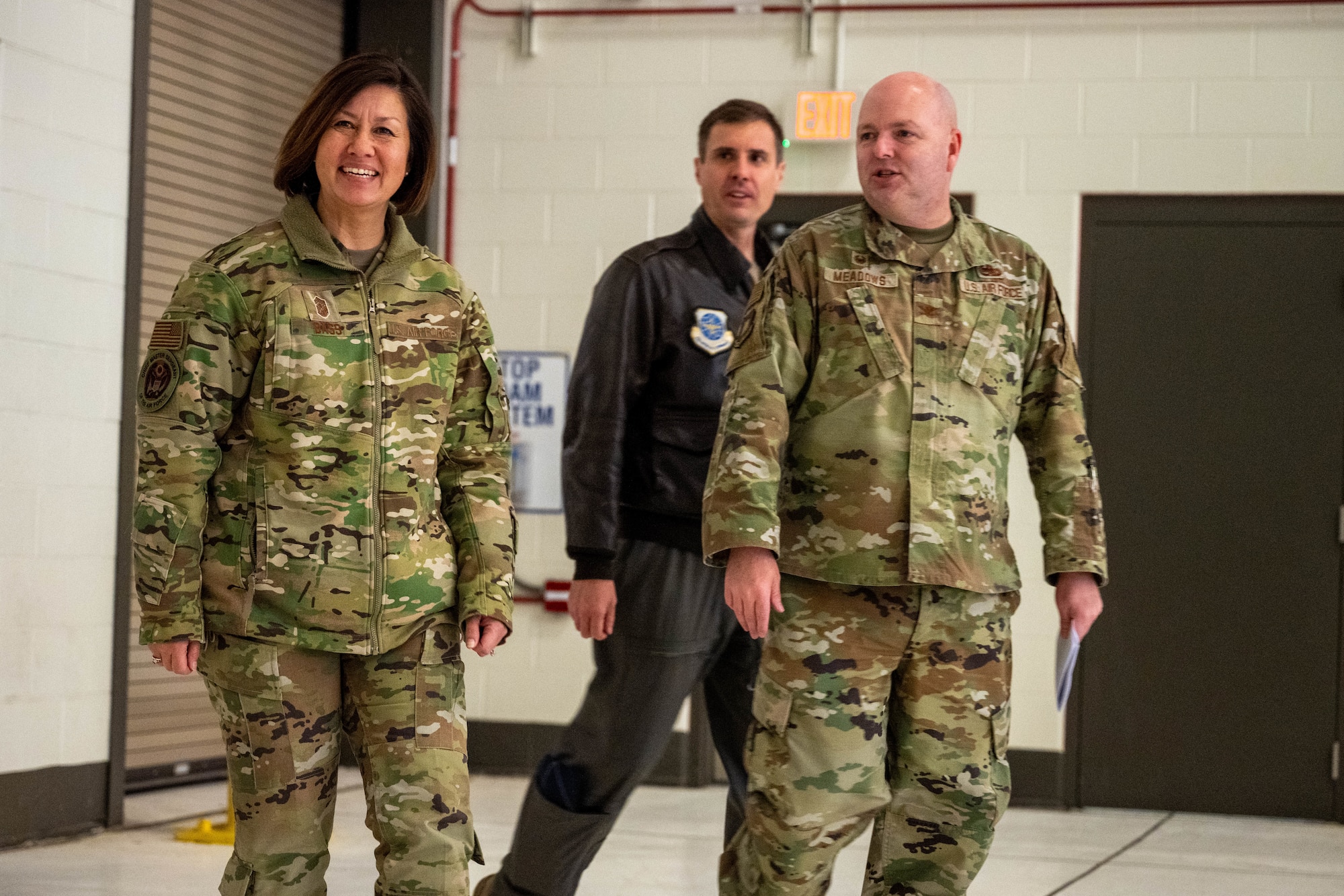 Col. Grant Meadows, 22nd Maintenance Group commander, right, and Col. Brent Toth, middle, 22nd Operations Group commander walks with Chief Master Sgt. of the Air Force JoAnne S. Bass, left, into a KC-46A hanger at McConnell Air Force Base, Kansas, Nov. 29, 2023. During her visit, Bass heard from the teams that keep the Pegasus in the air. (U.S. Air Force photo by Airman 1st Class Felicia Przydzial)