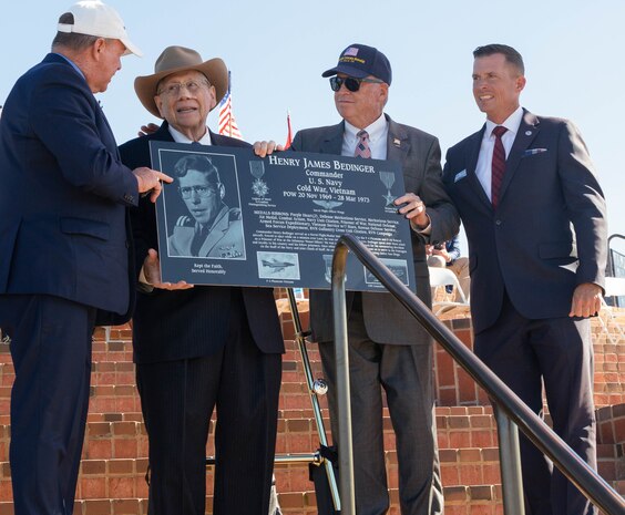 Retired U.S. Navy veteran Cmdr. Henry James Bedinger, second from left, special guest speaker, holds the sample of a plaque commemorating his military service, which will be added to the memorial wall of the Mt. Soledad National Veterans Memorial at the annual Mt. Soledad Veteran’s Day Ceremony in La Jolla, California, Nov. 11, 2023. Bedinger is a Vietnam War veteran, who served as an A-4 Radar intercept officer during the Vietnam War and was forced to eject during a flight over Laos. Bedinger was taken as prisoner of war for 1,223 days until he was released in March 1973. (U.S. Marine Corps photo by Staff Sgt. Melissa L. Karnath)