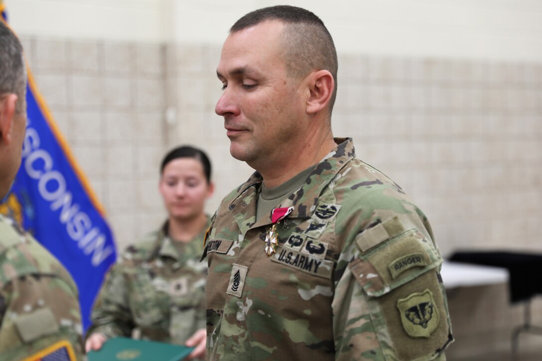 Command Sgt. Maj. Gregory Fulton, outgoing senior enlisted leader for the Wisconsin Army National Guard’s 64th Troop Command, is awarded the Legion of Merit from 64th commander Col. Jade Beehler for his 32 years of service and his leadership in the 64th Troop Command Dec. 2 at the US Armed Forces Reserve Center in Madison, Wis. The change of responsibility ceremony celebrates the outgoing command sergeant major and welcomes the incoming command sergeant major. 112th Mobile Public Affairs Detachment photo by Spc. Emiliano Alcorta