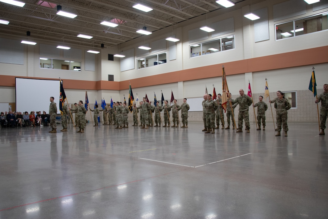 Guidon bearers of the battalions within 64th Troop Command Brigade stand in formation during a change of responsibility ceremony Dec. 2 at the Armed Forces Reserve Center in Madison, Wis. Command Sgt. Maj. Gregory Fulton relinquished his position within the 64th Troop Command to Command Sgt. Maj. John Buck after almost two years in that position. (U.S. Army National Guard photo by Spc. Abaigail Intine)