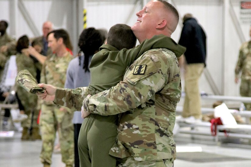 A service member holds a child.