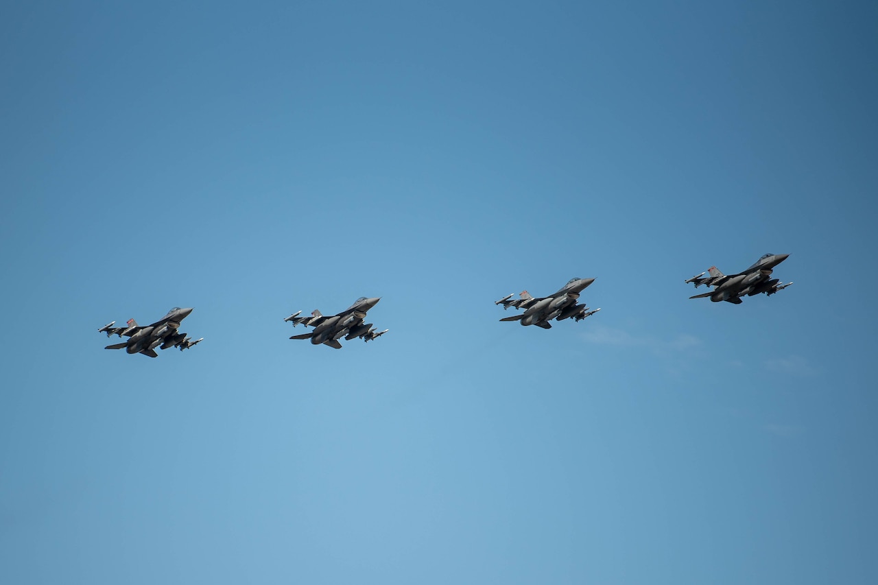 Military fighter jets fly in formation.