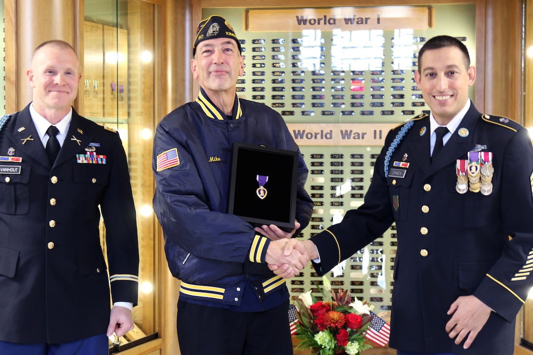 Maj. Eric Van Hout, an administrative officer with the Wisconsin Army National Guard’s 2nd Battalion, 127th Infantry Regiment, and Command Sgt. Maj. Ryan Johnson, battalion command sergeant major, present a Purple Heart medal to Mike Muthig, the grandson of World War I veteran Pvt. George Arts. Arts enlisted in the battalion’s Company I and was severely wounded Aug. 4, 1918, during the battalion’s assault on the town of Fismes.