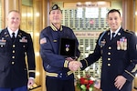 Maj. Eric Van Hout, an administrative officer with the Wisconsin Army National Guard’s 2nd Battalion, 127th Infantry Regiment, and Command Sgt. Maj. Ryan Johnson, battalion command sergeant major, present a Purple Heart medal to Mike Muthig, the grandson of World War I veteran Pvt. George Arts. Arts enlisted in the battalion’s Company I and was severely wounded Aug. 4, 1918, during the battalion’s assault on the town of Fismes.