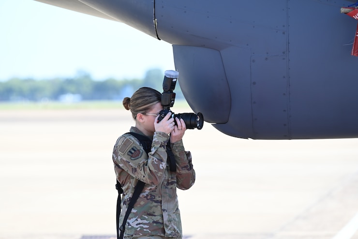 Public Affairs Airman takes photo after a change of command ceremony.