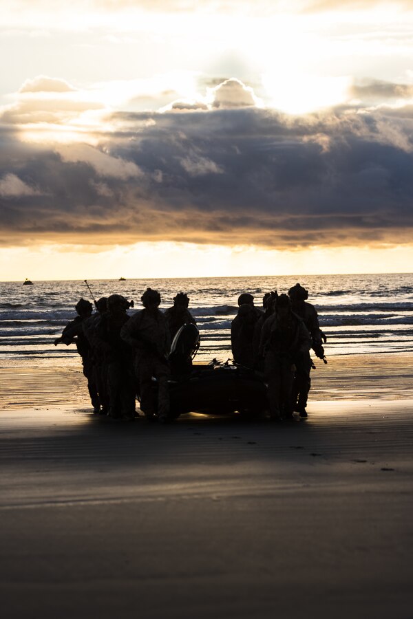 U.S. Marines with Charlie Company, 1st Reconnaissance Battalion, 1st Marine Division, carry a rigid-hull inflatable boat ashore at Red Beach during a raid as part of Exercise Steel Knight 23.2 at Marine Corps Base Camp Pendleton, California, Nov. 30, 2023. Steel Knight is a three-phase exercise designed to train I Marine Expeditionary Force in the planning, deployment and command and control of a joint force against a peer or near-peer adversary combat force and enhance existing live-fire and maneuver capabilities of the Marine Air-Ground Task Force. (U.S. Marine Corps photo by Cpl. Daniel)