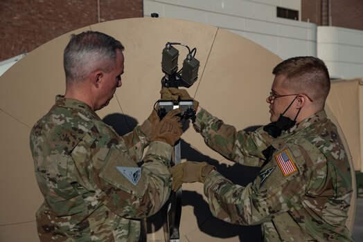  U.S. Space Force Tech. Sgt. John Idleman, Space Delta 3 – electromagnetic warfare, 16th Space Control Squadron mission assurance engineering section chief, demonstrates a feed swap on a Giggasat FA-150 antenna for USSF Lt. Gen. Stephen Whiting, Space Operations Command commander, at Peterson Space Force Base, Colorado, Dec. 13, 2021.