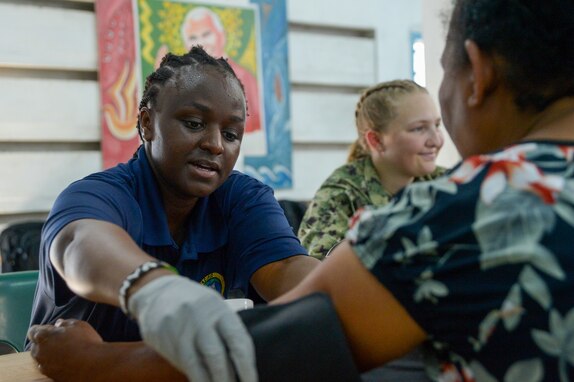 U.S. Navy Hospitalman Ruth Ndichu, from Mansfield, Texas, checks a local resident's blood pressure during a community health engagement at the Holy Cross Cathedral in Honiara, Solomon Islands, as part of Pacific Partnership 2024-1, Dec. 2, 2023. Pacific Partnership, now in its 19th iteration, is the largest multinational humanitarian assistance and disaster relief preparedness mission conducted in the Indo-Pacific and works to enhance regional interoperability and disaster response capabilities, increase security stability in the region, and foster new and enduring friendships. (U.S. Navy photo by Mass Communication Specialist 2nd Class Jacob Woitzel)