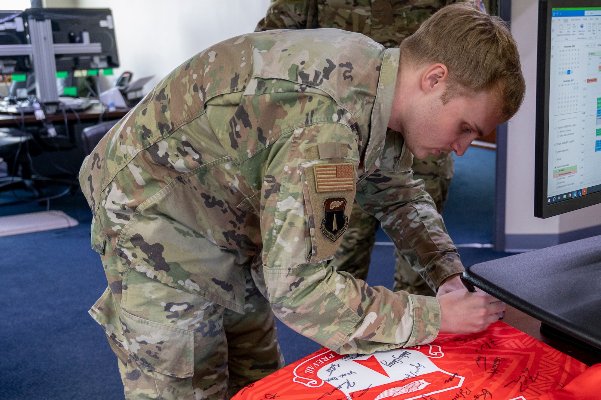 U.S. Air Force Senior Airman Tristan Lewis, a wing administrator for the 36th Wing, signs the official Linebacker of the Week jersey at Andersen Air Force Base, Guam, Nov. 29, 2023. The Team Andersen Linebacker of the Week recognizes outstanding enlisted, officer, civilian and total force personnel who have had an impact on achieving Team Andersen’s mission, vision and priorities. (U.S. Air Force photo by Senior Airman Emily Saxton)