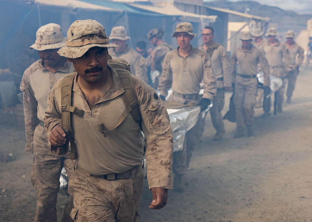 U.S. Marines and Sailors with Fox Company, 2nd Battalion, 5th Marine Regiment, 1st Marine Division, provide aid during a mass casualty training scenario for a simulated embassy reinforcement during a mission rehearsal exercise as part of Exercise Steel Knight 23.2 at Marine Corps Base Camp Pendleton, California, Nov. 29, 2023. Steel Knight maintains and sharpens I Marine Expeditionary Force as America’s expeditionary force in readiness – organized, trained and equipped to respond to any crisis, anytime, anywhere. This exercise will certify 5th Marines to be forward-postured in Australia as Marine Rotational Force - Darwin, a six-month deployment during which Marines train with Australian allies and facilitate rapid response to crises and contingencies. (U.S. Marine Corps photo by Cpl. Earik Barton)