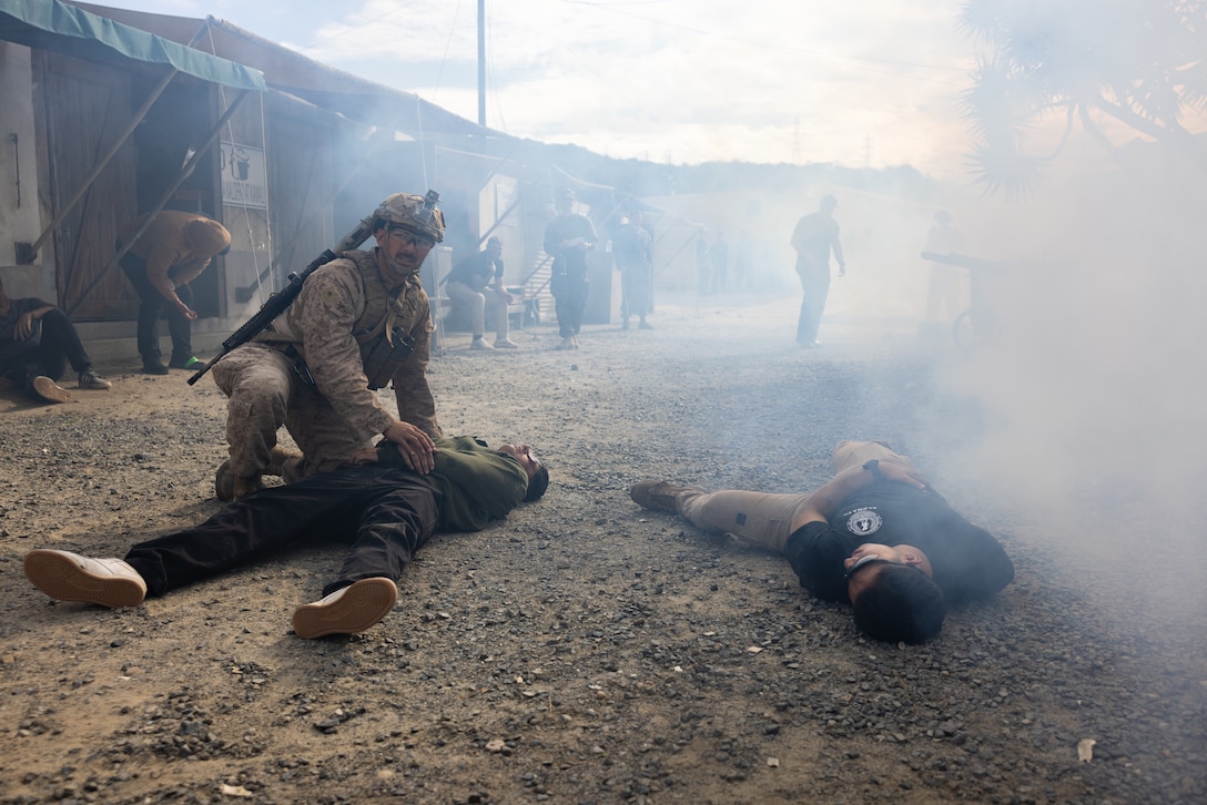 A U.S. Marine with Fox Company, 2nd Battalion, 5th Marine Regiment, 1st Marine Division, provides aid to a simulated civilian casualty during a mass casualty training scenario for a simulated embassy reinforcement during a mission rehearsal exercise as part of Exercise Steel Knight 23.2 at Marine Corps Base Camp Pendleton, California, Nov. 29, 2023. Steel Knight maintains and sharpens I Marine Expeditionary Force as America’s expeditionary force in readiness – organized, trained and equipped to respond to any crisis, anytime, anywhere. This exercise will certify 5th Marines to be forward-postured in Australia as Marine Rotational Force - Darwin, a six-month deployment during which Marines train with Australian allies and facilitate rapid response to crises and contingencies. (U.S. Marine Corps photo by Cpl. Earik Barton)