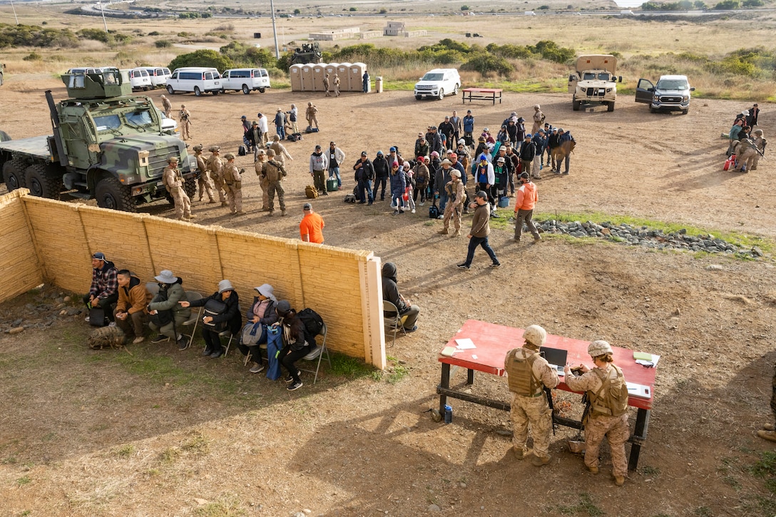 U.S. Marines with Combat Logistics Battalion 5, Combat Logistics Regiment 1, 1st Marine Logistics Group, process role-players at an evacuation control center during a mission rehearsal exercise as part of Exercise Steel Knight 23.2 at Marine Corps Base Camp Pendleton, California, Dec. 1, 2023. Steel Knight maintains and sharpens I Marine Expeditionary Force as America’s expeditionary force in readiness – organized, trained and equipped to respond to any crisis, anytime, anywhere. This exercise will certify the battalion and 5th Marine Regiment, 1st Marine Division, to be forward-postured in Australia as Marine Rotational Force - Darwin, a six-month deployment during which Marines train with Australian allies and facilitate rapid response to crises and contingencies. (U.S. Marine Corps photo by Sgt. Cristian Bestul)