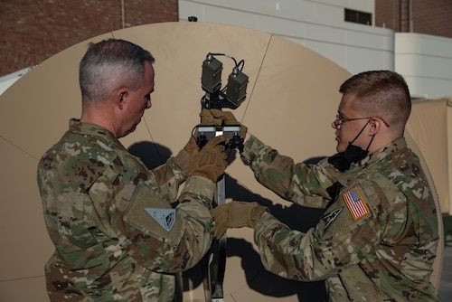 U.S. Space Force Tech. Sgt. John Idleman, Space Delta 3 – electromagnetic warfare, 16th Space Control Squadron mission assurance engineering section chief, demonstrates a feed swap on a Giggasat FA-150 antenna for USSF Lt. Gen. Stephen Whiting, Space Operations Command commander, at Peterson Space Force Base, Colorado, Dec. 13, 2021.