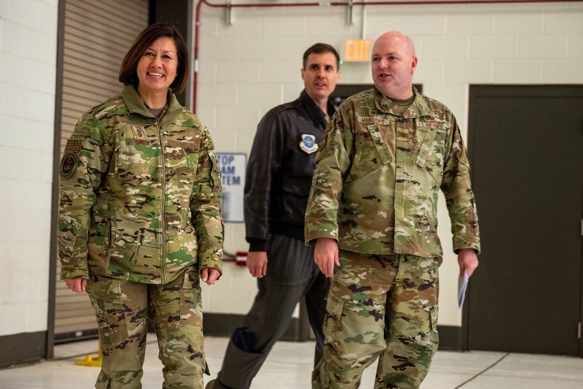 Col. Grant Meadows, 22nd Maintenance Group commander, right, and Col. Brent Toth, middle, 22nd Operations Group commander walks with Chief Master Sgt. of the Air Force JoAnne S. Bass, left, into a KC-46A hanger at McConnell Air Force Base, Kansas, Nov. 29, 2023. During her visit, Bass heard from the teams that keep the Pegasus in the air. (U.S. Air Force photo by Airman 1st Class Felicia Przydzial)