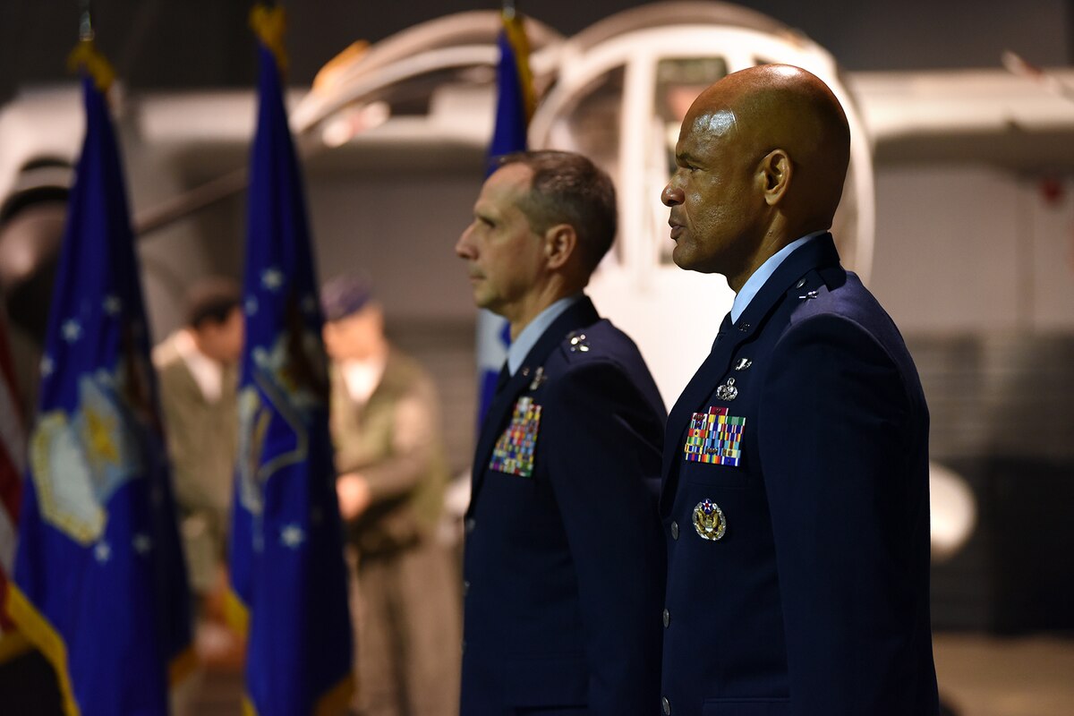 Two men in blues uniform stand at attention.